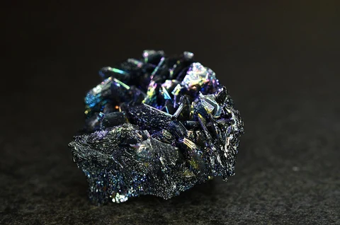 Iridescent silicon-carbide crystal against a plain background.