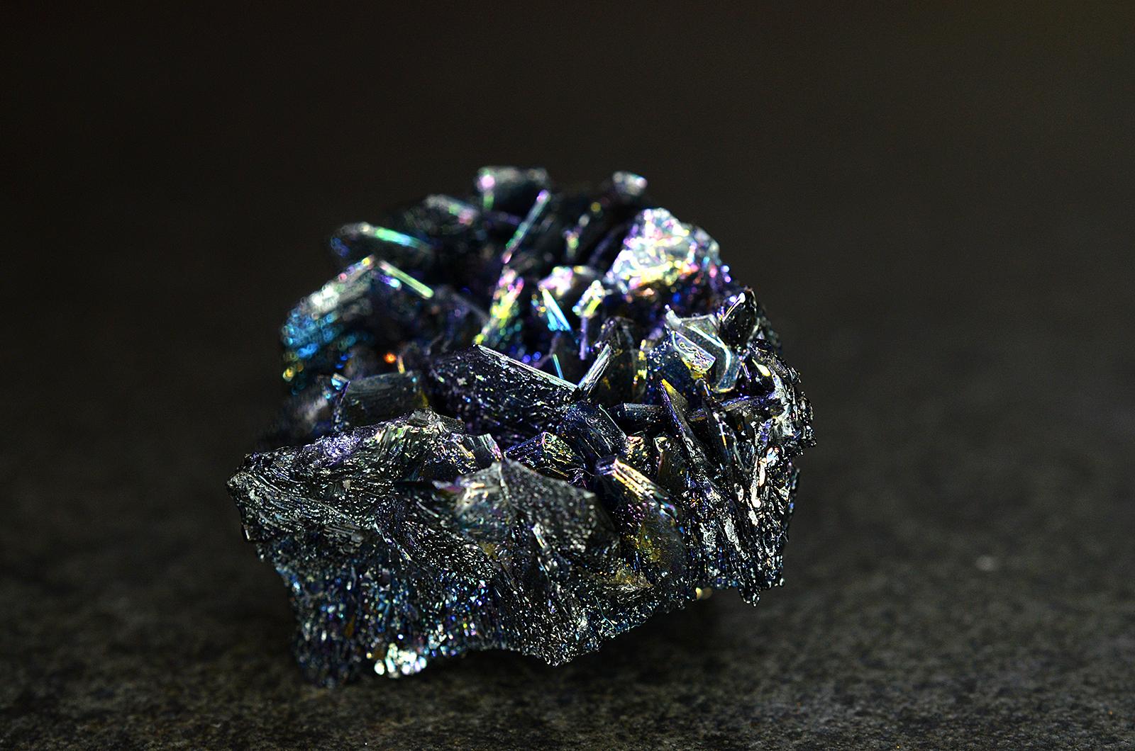 Iridescent silicon-carbide crystal against a plain background.