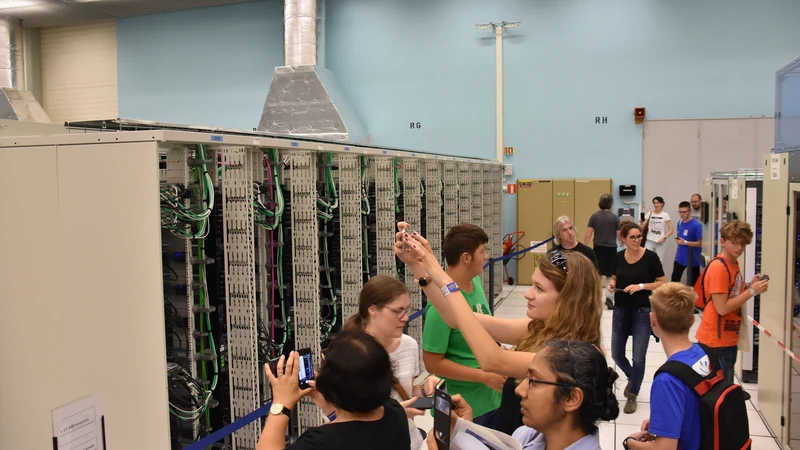 Visitors photographing server racks and cables during a CERN computer-centre tour.