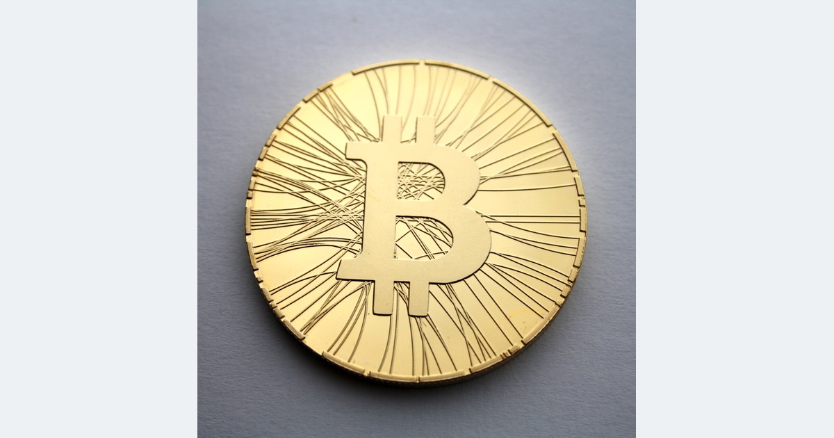 Gold-coloured physical token bearing the Bitcoin symbol.