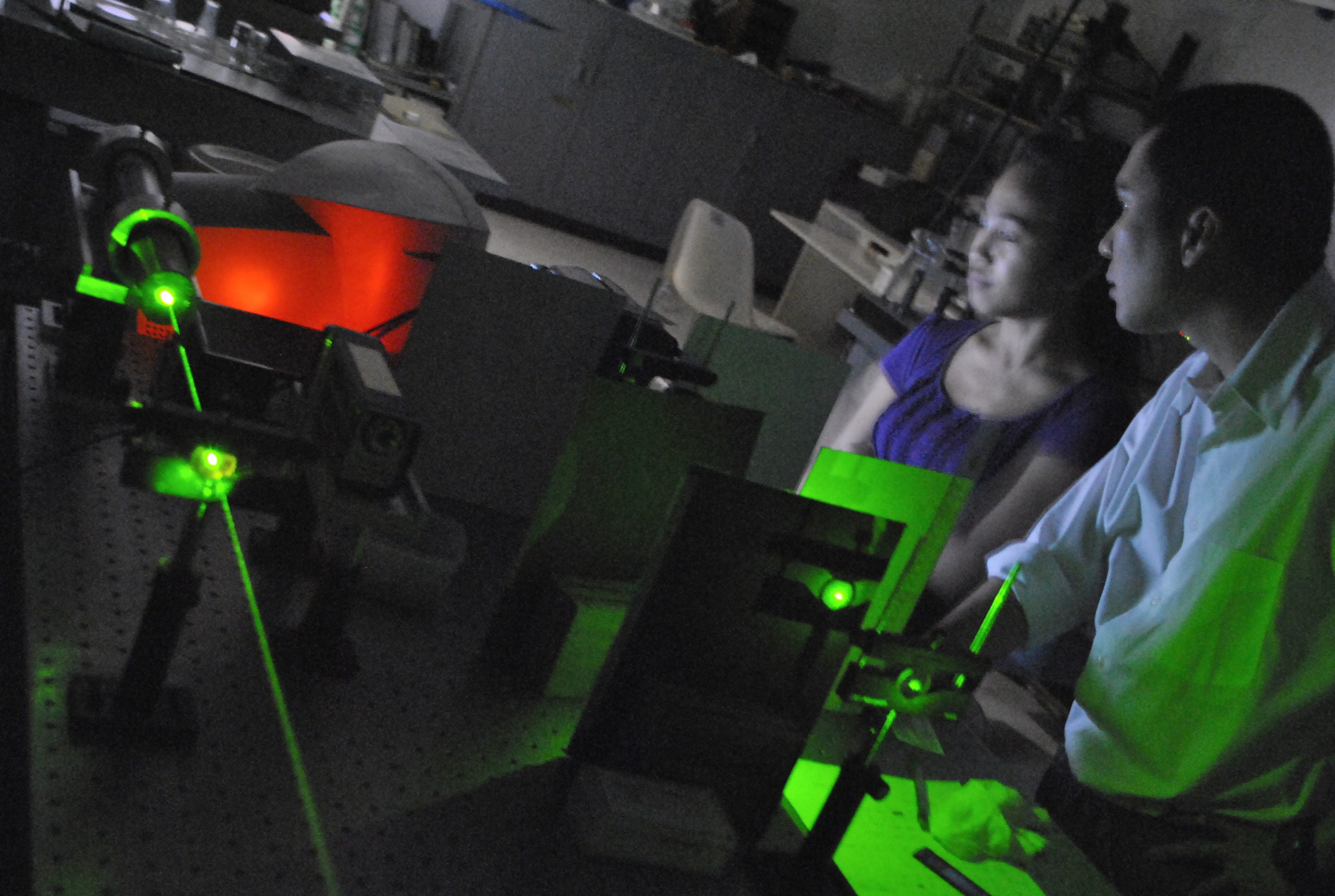 Dr. Raphael Guerrero and a student conducting a laser experiment on an optical table at Ateneo de Manila University.