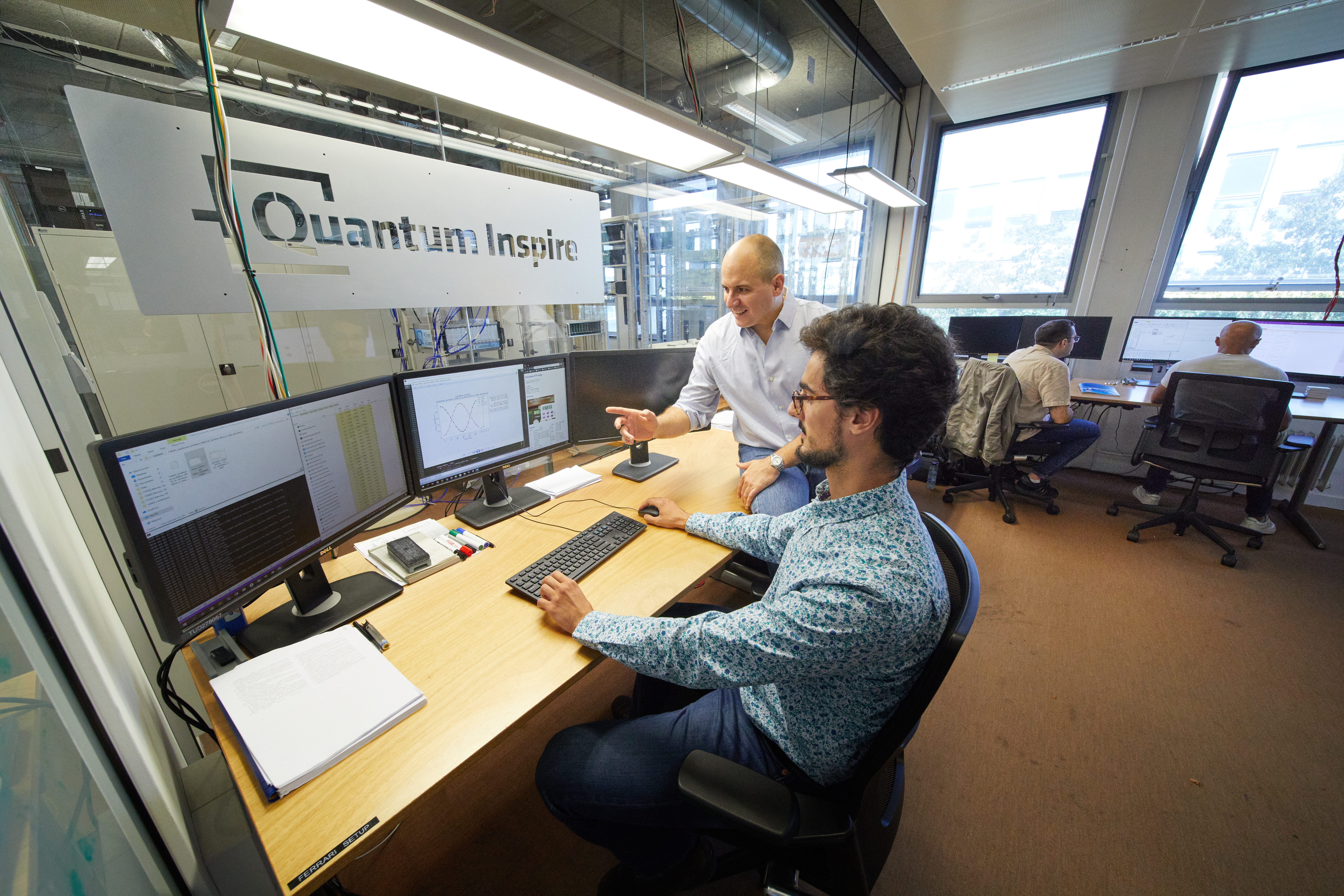 Researchers work at computer monitors in a QuTech laboratory marked Quantum Inspire.