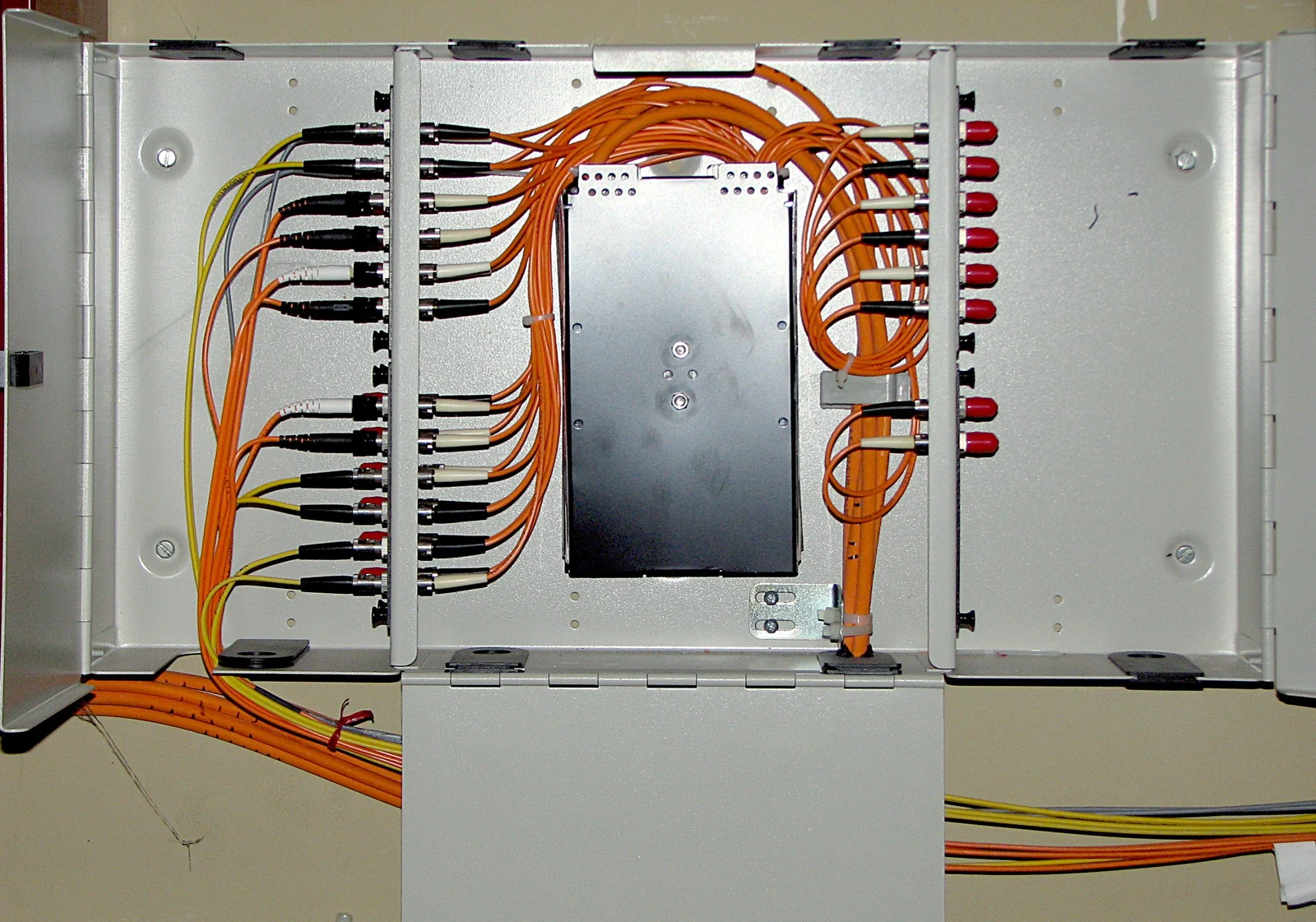 Optical-fiber cables connected inside a distribution cabinet.