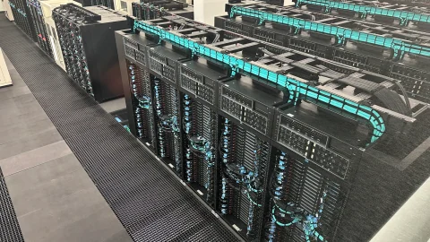 Rows of MareNostrum 5 supercomputer cabinets with turquoise cooling lines at the Barcelona Supercomputing Center