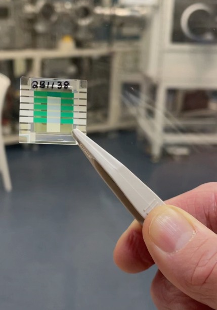 Tweezers holding CSIRO’s small layered quantum-battery prototype.