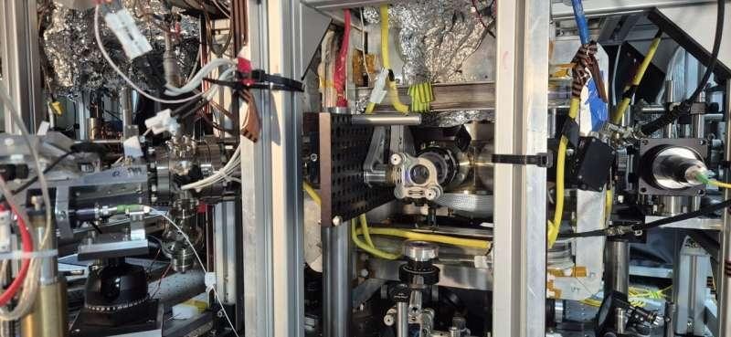 Wide view of the Quantum Galileo Interferometer’s vacuum chamber and surrounding laboratory equipment.
