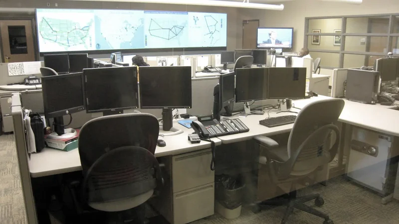 Desks, monitors and wall displays in a network operations center.