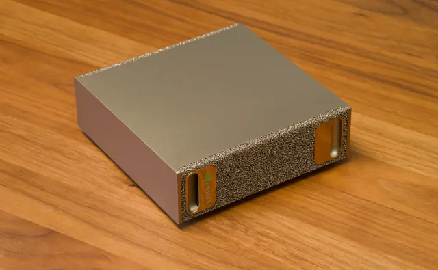 An NVIDIA DGX Spark desktop computer seen obliquely, with a gold-colored metal case and ventilated front.