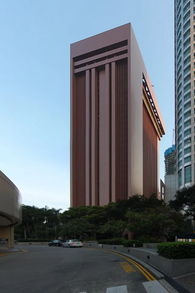The Monetary Authority of Singapore building stands beside a city street and trees.