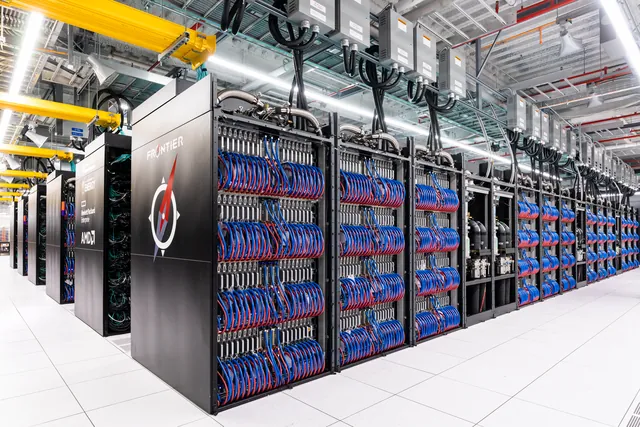 Frontier supercomputer cabinets and cooling infrastructure fill a machine room.