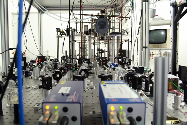 Two diode-laser units and an optical table filled with lenses and mirrors in a laboratory.