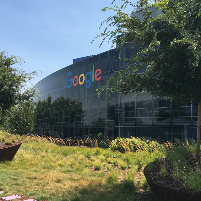Google offices, trees and a landscaped courtyard beneath a clear sky.