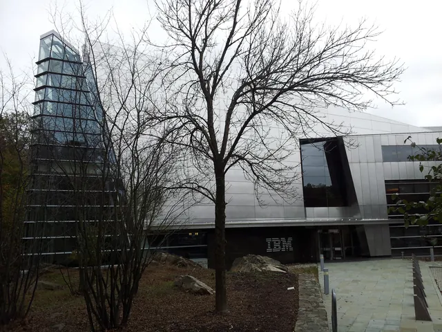 IBM’s corporate headquarters appears behind trees with the IBM name beside the entrance.