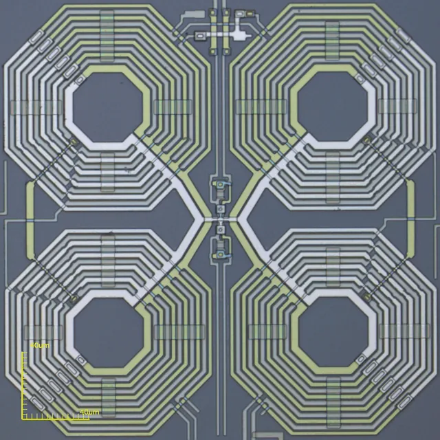 A microscope image shows repeated metal coils and two small squares in a SQUID amplifier.