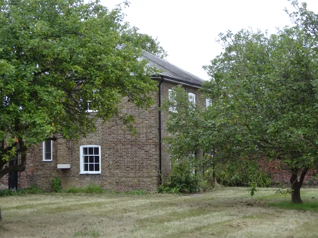 A historic National Physical Laboratory building sits among trees and grass.