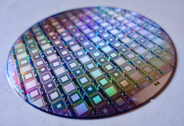A circular D-Wave wafer contains many square superconducting processor dies.