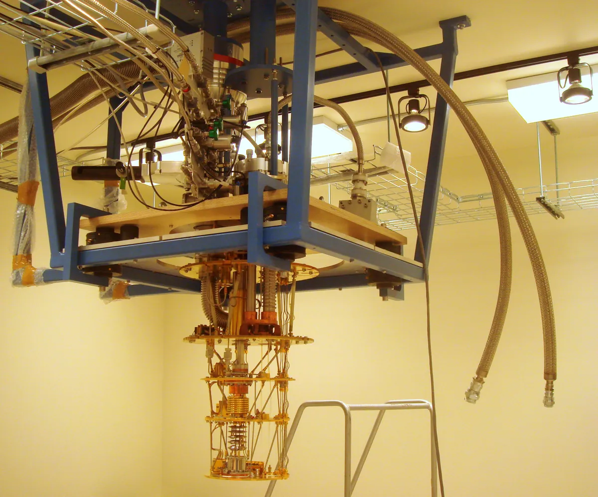 An open dilution refrigerator with metallic cooling stages and wiring.