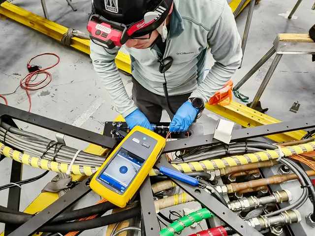 A technician checks an optical-fiber assembly using a handheld instrument.
