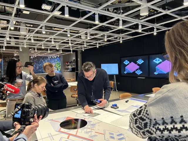 Visitors examining small computing exhibits on a demonstration table at IBM.