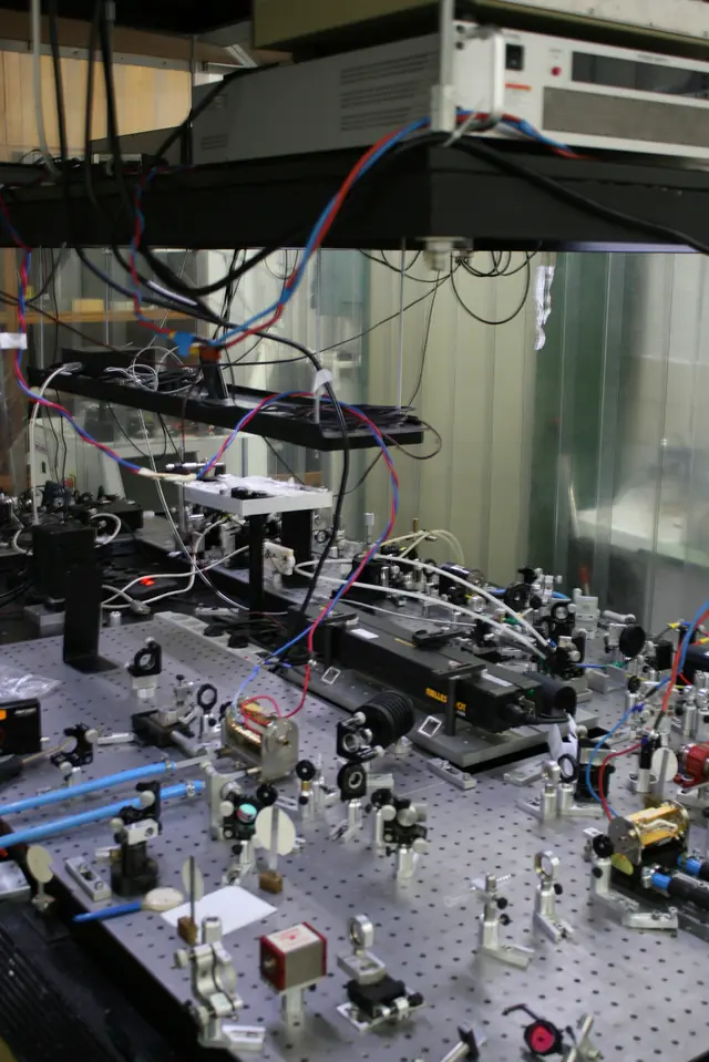Mirrors, mounts and optical components arranged on a laboratory table.