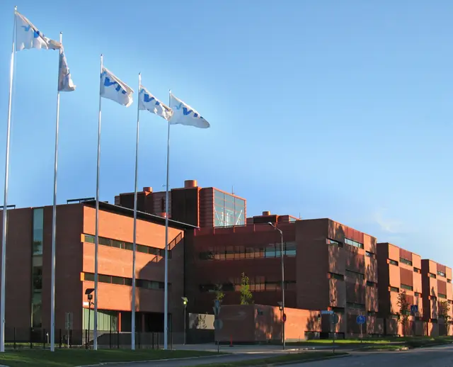 VTT’s brick headquarters building and flags in Espoo, Finland.