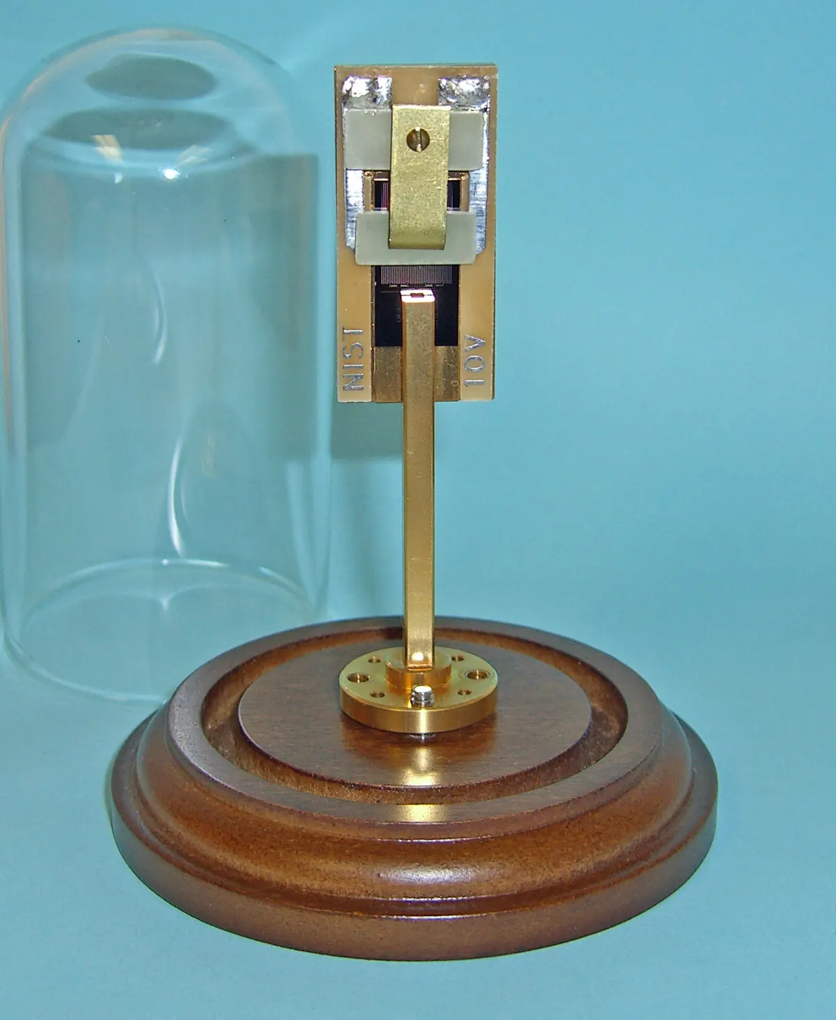 An archival metal chip-holder and microwave-waveguide assembly on a circular base.