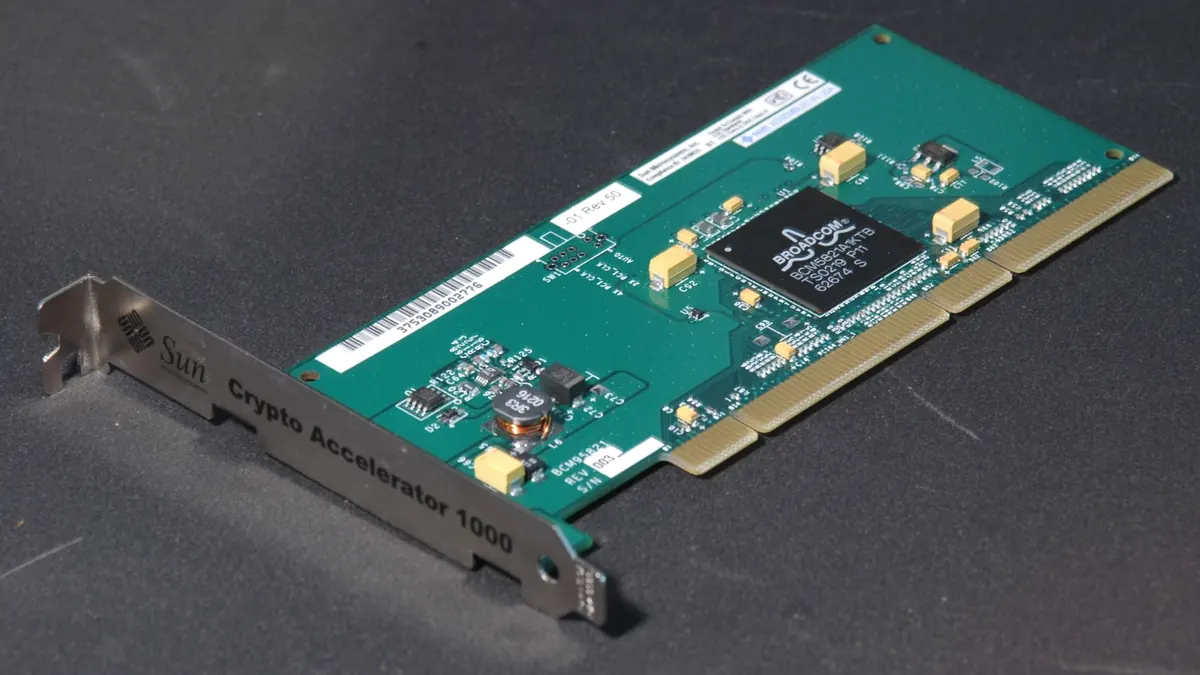 A green cryptographic accelerator circuit board with a metal mounting bracket.