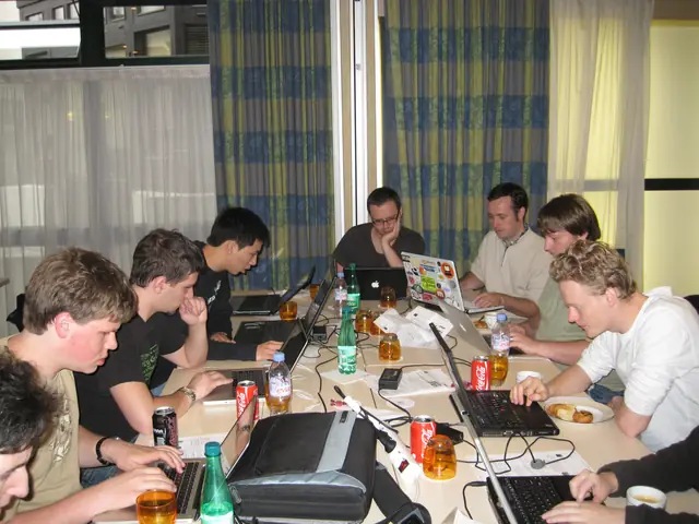 Workshop participants seated around a table with laptops and notebooks.