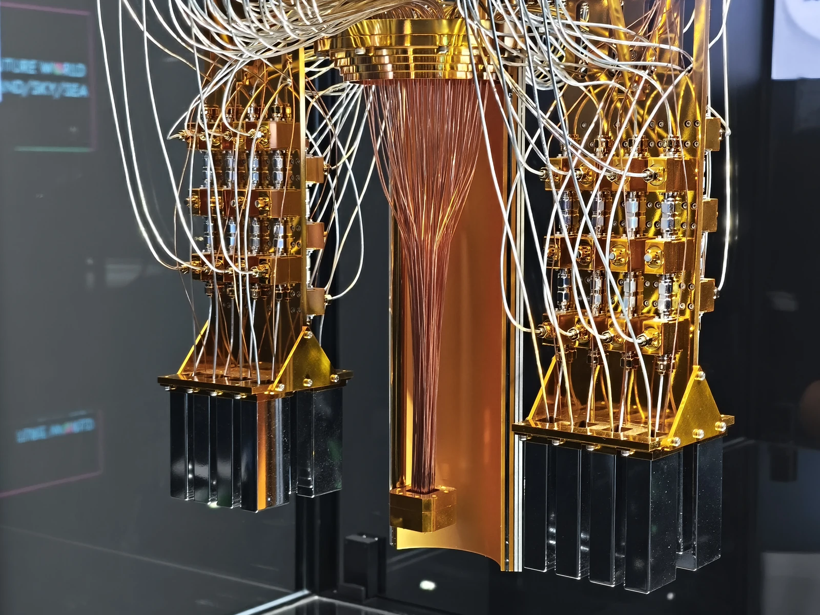 Thin cables descend and curve around a central gold-colored post, with several dark cylindrical components hanging below.