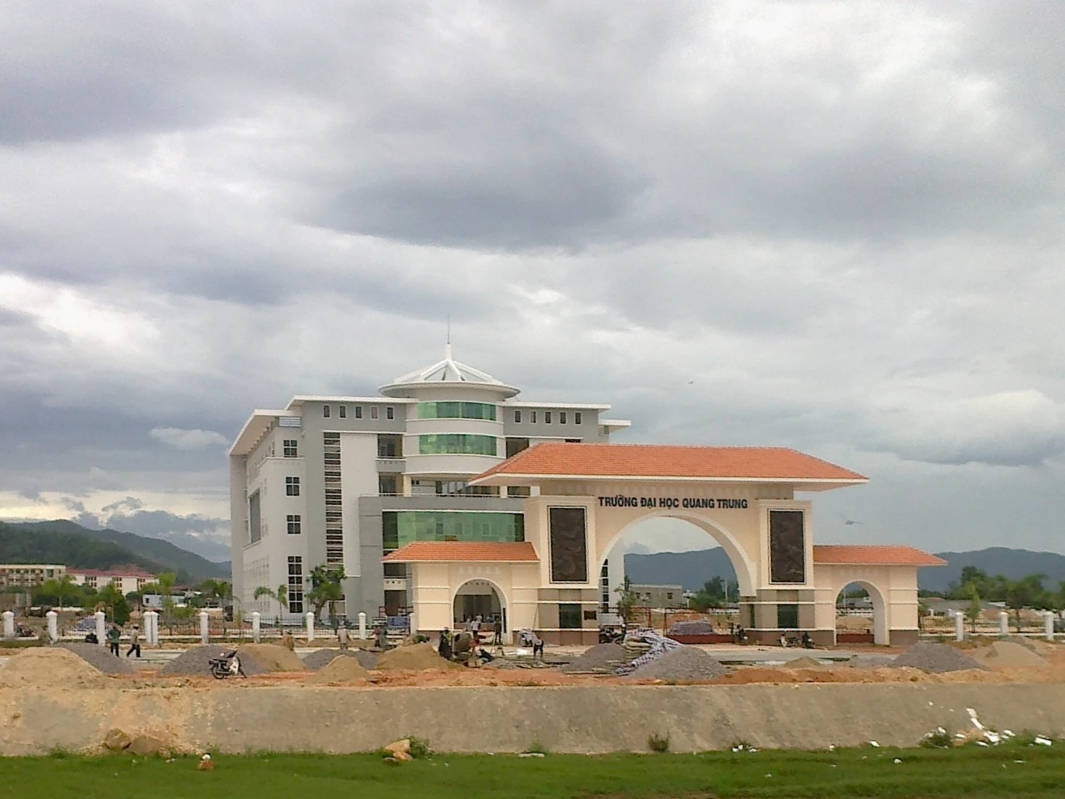 Archival 2011 view of Quang Trung University’s entrance arch and campus building in Vietnam.