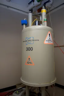 A tall Bruker 300 MHz NMR spectrometer stands in a laboratory at Columbia University.