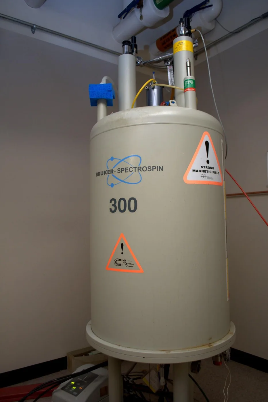A tall Bruker 300 MHz NMR spectrometer stands in a laboratory at Columbia University.