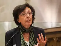 Giulia Galli speaks beside a microphone and gestures with one hand.