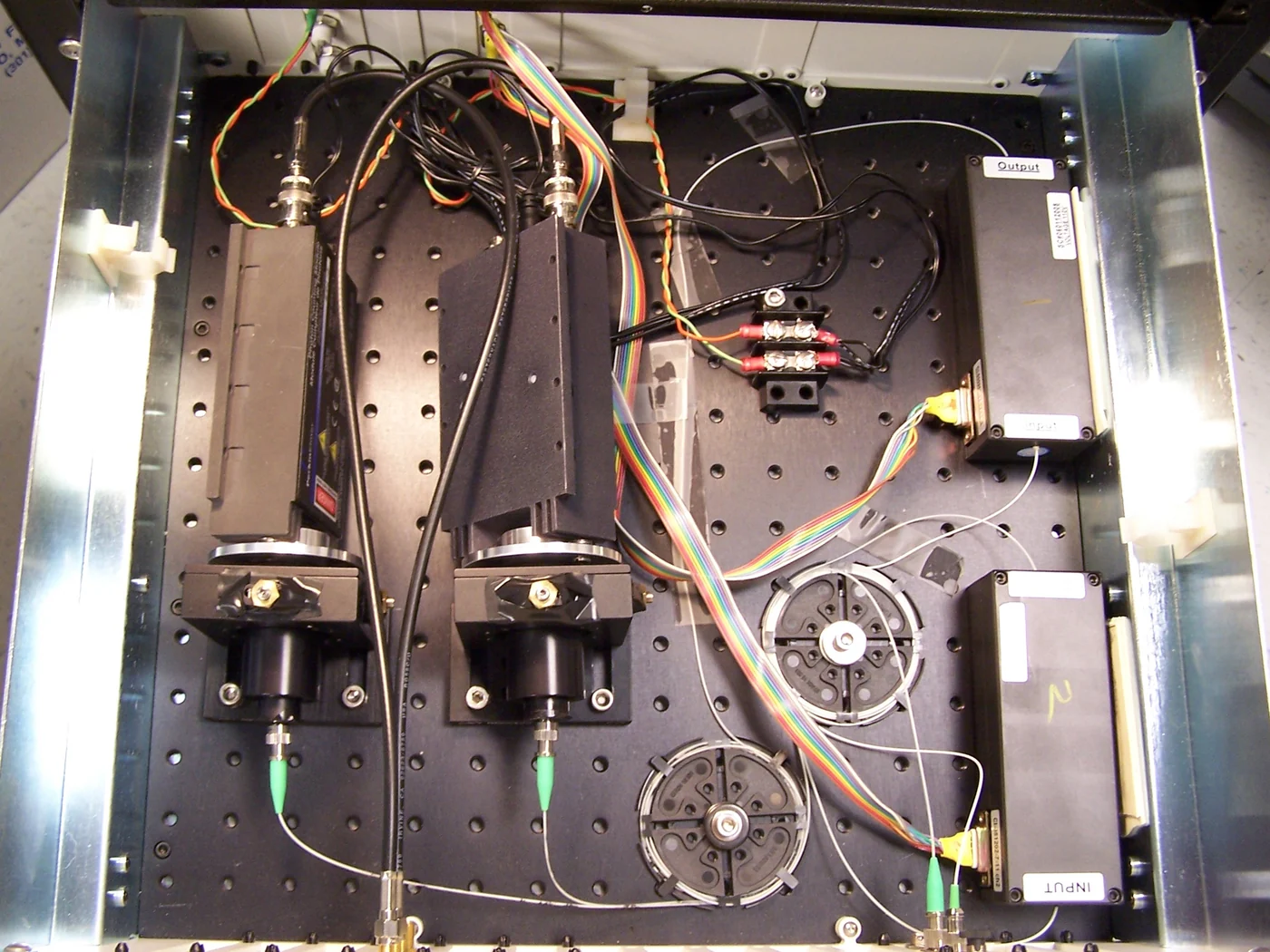 Open instrument enclosure showing optical components, wires and a detector assembly.