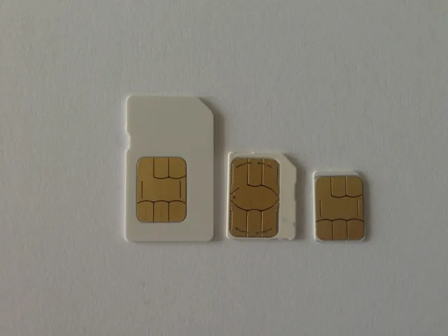 Three gold-contact SIM cards of decreasing size on a pale surface.