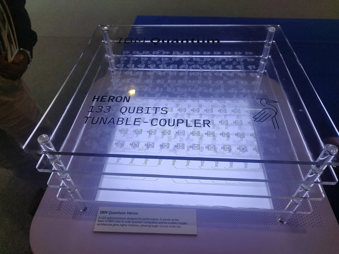 A transparent display model labeled Heron with layers representing qubits and tunable couplers.
