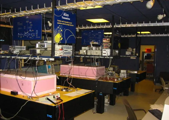 Two optical tables and instrument shelves form the historical Alice and Bob network nodes.