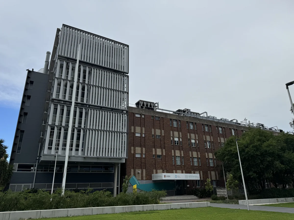 UNSW laboratory building with a tall white facade, brick wing and quantum-computation centre signage near the entrance.