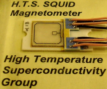 A historical SQUID sensor mounted with wires on a labeled card.